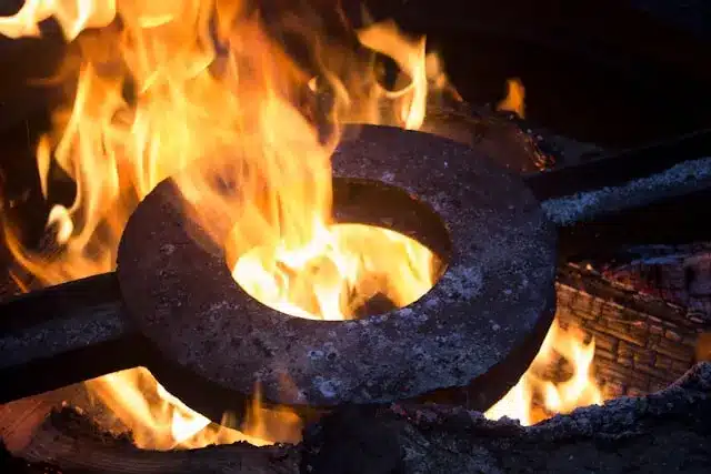 Open die forging process with heated metal glowing in a forging furnace, illustrating conditions that can lead to forging defects and the importance of defect prevention.